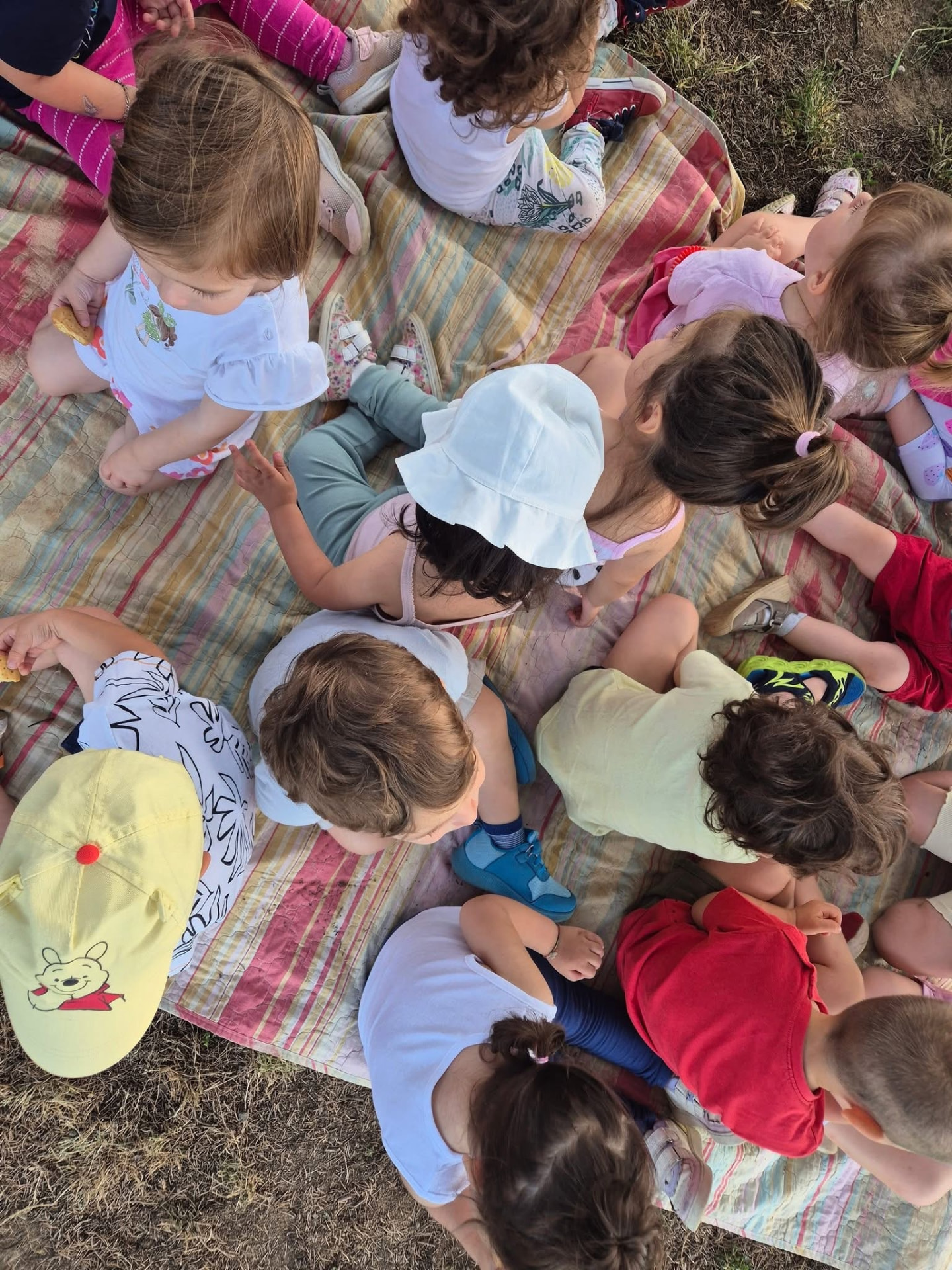 Bambini seduti sul telo durante l'attività all'aperto