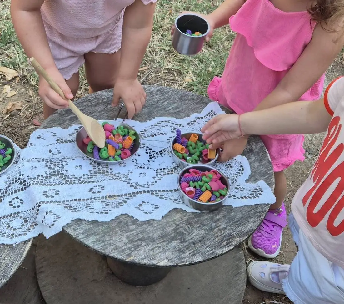 Bambine giocano a cucinare con pasta colorata all'aperto